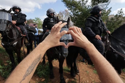 La policía israelí montada hace guardia mientras un manifestante hace un gesto de corazón durante las protestas en Jerusalén, este lunes. 