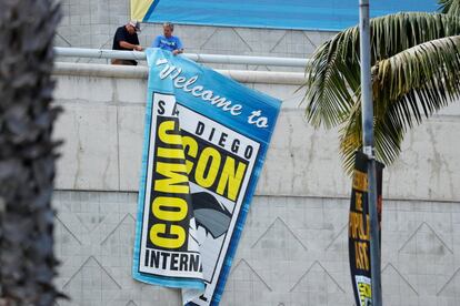 Operarios cuelgan el cartel de bienvenida a la Comic-Con en la fachada del edificio que acogerá la convención este año en San Diego, el 17 de julio.