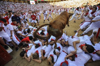 Una vaquilla salta por encima de los corredores durante el segundo encierro de las fiestas de San Fermín que se celebra en la ciudad de Pamplona, España.