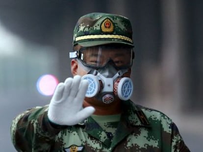 Um policial para a um fotógrafo que pretendia aceder à zona que foi evacuada em Tianjin, nesta segunda-feira.