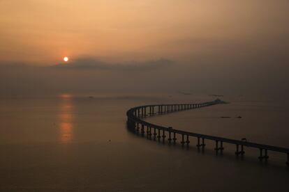 La obra, con un coste de más de 16.000 millones de euros, ha sido financiada por los gobiernos chino, de Hong Kong y de Macao. En la imagen, el sol del atardecer ilumina la infraestructura.