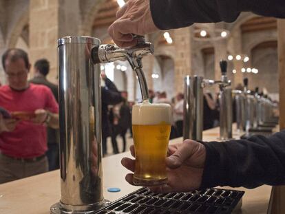 Un camarero sirve una ca&ntilde;a en un bar de Barcelona