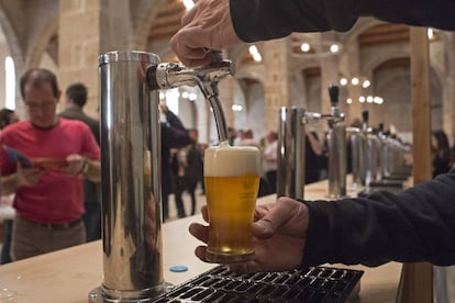 Un camarero sirve una caña en un bar de Barcelona