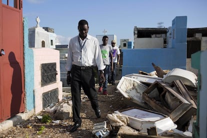 Jerry Chery, subdirector del cementerio, camina entre ataúdes rotos en el cementerio nacional de Puerto Príncipe, en Haití. Durante el paseo se pueden apreciar de esqueletos que yacían en ataúdes abiertos, costillas y vértebras dispersas aún dentro de los trajes blanqueados por el sol y los lazos aún atados. Unos cuantos cuerpos arrojados al suelo por los trabajadores aún tenían la piel momificada en sus cráneos.