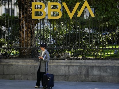 Una mujer en frente de un edificio del BBVA en Madrid.