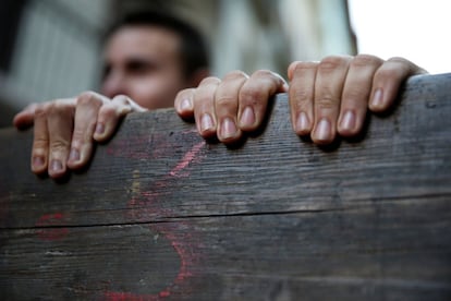 Dos personas se agarran a una de las vallas que enmarca el recorrido de los toros durante los encierros de San Fermín.