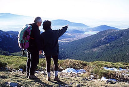 Dos montañeros contemplan el horizonte de Guadarrama desde la loma del Noruego.