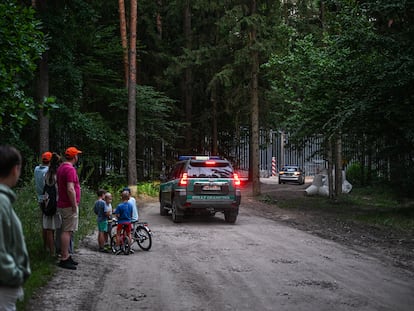 Un grupo de personas observa en la distancia la valla en la frontera entre Polonia y Bielorrusia, en Bialowieza, el pasado julio.