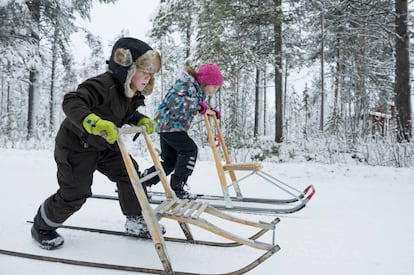 Dos niños con trineos de nieve en Laponia.
