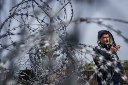 Un refugiado habla a los periodistas tras las concertinas en el lado serbio de la frontera sur hngara con Serbia, cerca de Tompa, Hungra.