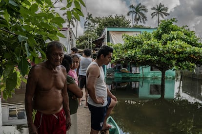 La familia Pérez en la entrada de su casa donde están viviendo ahora 14 familias.