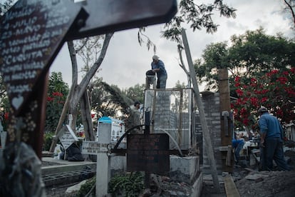 Trabajadores del cementerio de San Lorenzo Tezonco, en Iztapalapa, Ciudad de México, construyen una tumba antes de las celebraciones por el Día de Muertos.