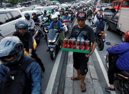 Un vendedor de bebidas, durante las horas punta de tráfico en Yakarta, Indonesia.