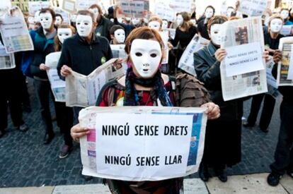 Unos 200 sin hogar miembros de las asociaciones protestan con máscaras blancas en la plaza de Sant Jaume de Barcelona contra la marginación que sufre el colectivo discriminación del colectivo.