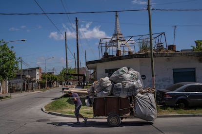 Para el escritor Pedro Saborido, autor de 'Una historia del conurbano', estas construcciones hacen que la calle se vuelva "la sala de estar del pueblo". A su vez, explica que son la identidad de una sociedad que suele ser tratada con desdén por los capitalinos. En la imagen, un recolector de basura jala una carreta junto a una casa con una réplica de la Torre Eiffel sobre el techo, en el barrio de La Tablada. 