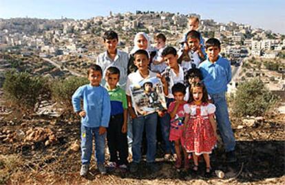 Fátima Abayat, madre de Ibrahim, uno de los tres palestinos deportados a España, posa con sus nietos cerca de su casa en Belén.