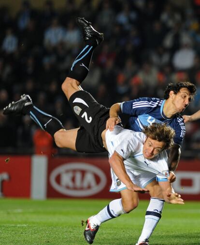 Los jugadores Diego Lugano y Nicolás Burdiso durante el partido entre Uruguay y Argentina