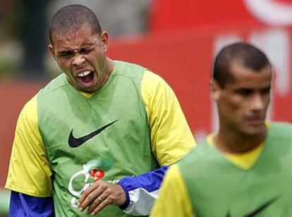 Ronaldo, tras Rivaldo, bosteza durante un entrenamiento de la selección brasileña.