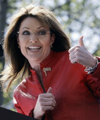 Sarah Palin saluda a su marido antes de dirigirse al público en una reunión de los <i>tea party.</i>