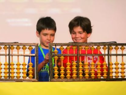 Dos niños aprenden cálculo con el ábaco japonés.
