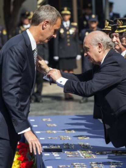 El ministro del Interior, Jorge Fernández Díaz, condecora al director de la Interpol, Rob Wainwright.