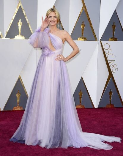 A modelo Heidi Klum foi ao Oscar com um vestido assimétrico em tons de lilás, de gaze com flores, decote até a cintura e manga, assinado por Marchesa.