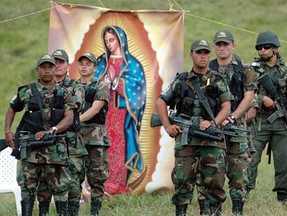 Un grupo de paramilitares entrega las armas, con la imagen de una virgen de fondo, al noroeste de Colombia.