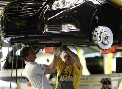 Dos operarios trabajan en una cadena de montaje de la automovilística Opel, en Ruesselsheim.