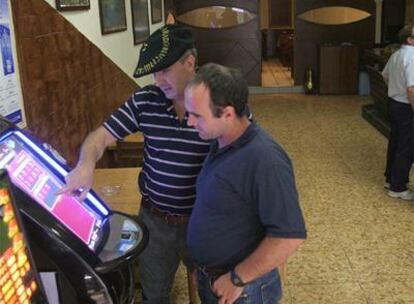 Dos parroquianos observan el funcionamiento de una máquina de apuestas en el bar Kantabrico de Tolosa, uno de los <i>santuarios</i> de las apuestas tradicionales en Euskadi.
