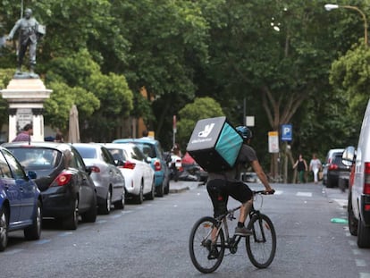 Un repartidor-mensajero de la empresa Deliveroo, en bicicleta por el centro de Madrid