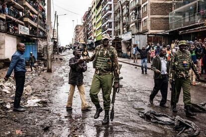 Un ciudadano agradece a los oficiales de la Policía keniana mientras pasa frente a un grupo de manifestantes que intentaban evitar la votación en el colegio electoral de Mathare, Nairobi, este jueves, 26 de octubre de 2017.