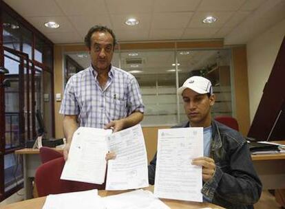 Hassan Aimani, técnico de CC OO, junto a Sahli, que muestra el contrato de trabajo que ha firmado para conseguir papeles.