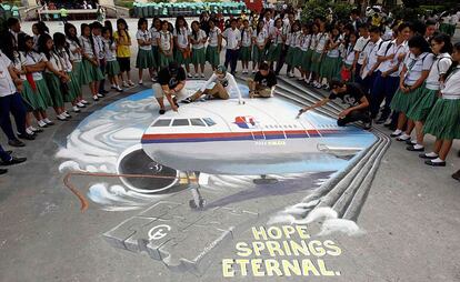 Unos estudiantes terminan un dibujo en recuerdo al avión desaparecido en un colegio de la ciudad de Makati (Manila), 17 de marzo de 2014.