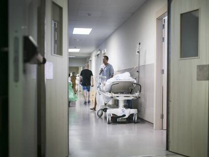 Un pacient espera en una llitera en un passadís de Vall d'Hebron el 2015.