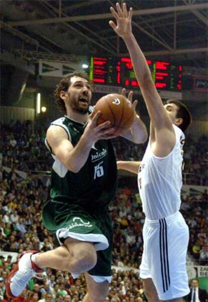 Garbajosa, del Unicaja, entra a canasta con la oposición de Felipe Reyes.