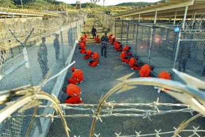 Los primeros presos llevados a la base de Guantánamo, el 11 de enero de 2002, esperan mientras se tramita su ingreso en la prisión.