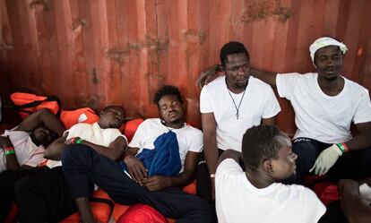 Un grupo de migrantes a bordo del 'Aquarius' descansa en la cubierta del barco este martes a la espera de ser trasladados a Valencia.