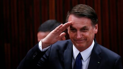 Bolsonaro saluda antes de recibir el diploma del Tribunal Electoral.