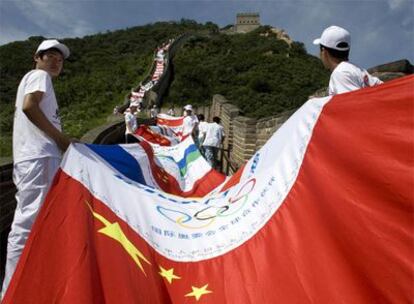 Voluntarios chinos sostienen una bandera formada con distintos escudos nacionales.