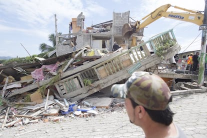 Un residente observa una casa que se derrumbó con el terremoto.