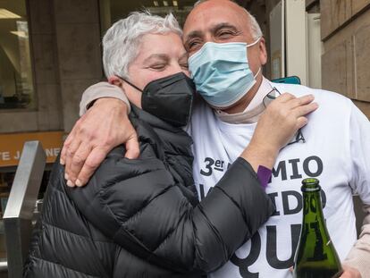 Isabel, una agraciada con un décimo del tercer premio de la lotería, se abraza al lotero que ha repartido la suerte en Valencia, MIguel Ángel Olmedo.