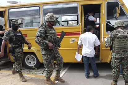 Forensic personnel and members of the Navy work at a crime scene in which a bus driver and his two assistants were killed by gunmen inside a bus in Acapulco's Cayaco neigbourhood.