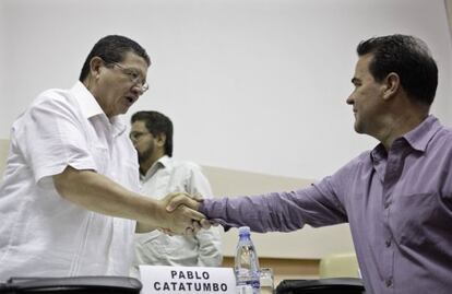 FARC negotiator Pablo Catatumbo (l) shakes hands with Colombia's government negotiator Frank Pearl in Havana Sunday.