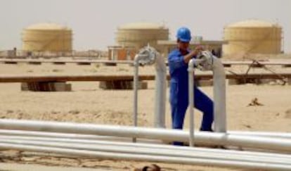 Un operario abre una v&aacute;lvula en una refiner&iacute;a de Najaf, en Irak.