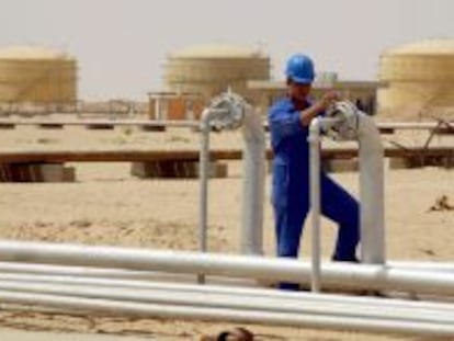 Un operario abre una v&aacute;lvula en una refiner&iacute;a de Najaf, en Irak.