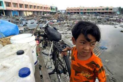 Un niño permanece junto a la que hasta hace unos días era su casa, hoy un puñado de escombros en Banda Aceh.