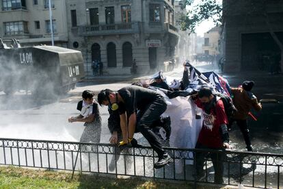 Los manifestantes huyen al chocar con la policía antidisturbios al terminar la manifestación en Santiago de Chile.