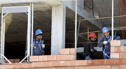 Tres obreros trabajan en una vivienda.