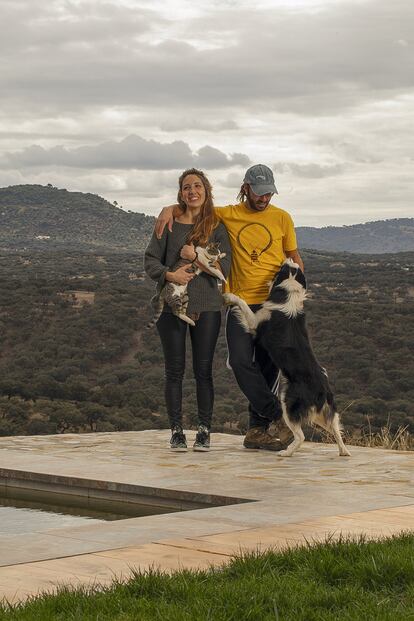Daniel Cabello y Carmen Quintanilla posan junto a su casa de campo, que han construido en la finca que heredaron de la madre de Quintanilla. Su perro Mendi, 'monte' en euskera, se suma a la foto.