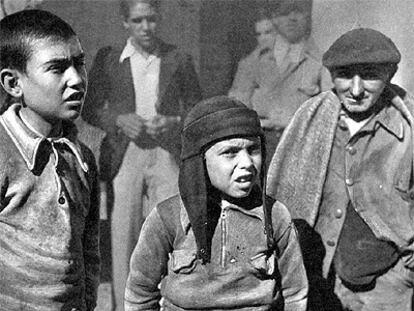 Niños y mayores salen a la calle después de un bombardeo aéreo sobre Madrid.